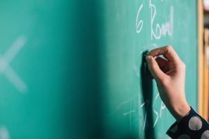 On teacher appreciation day, a hand writes on a chalk board
