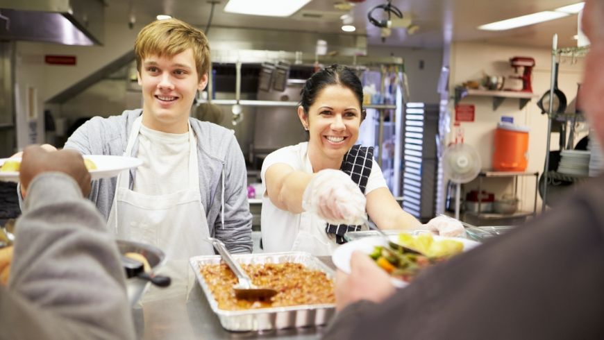 Volunteer serving food in homeless shelter